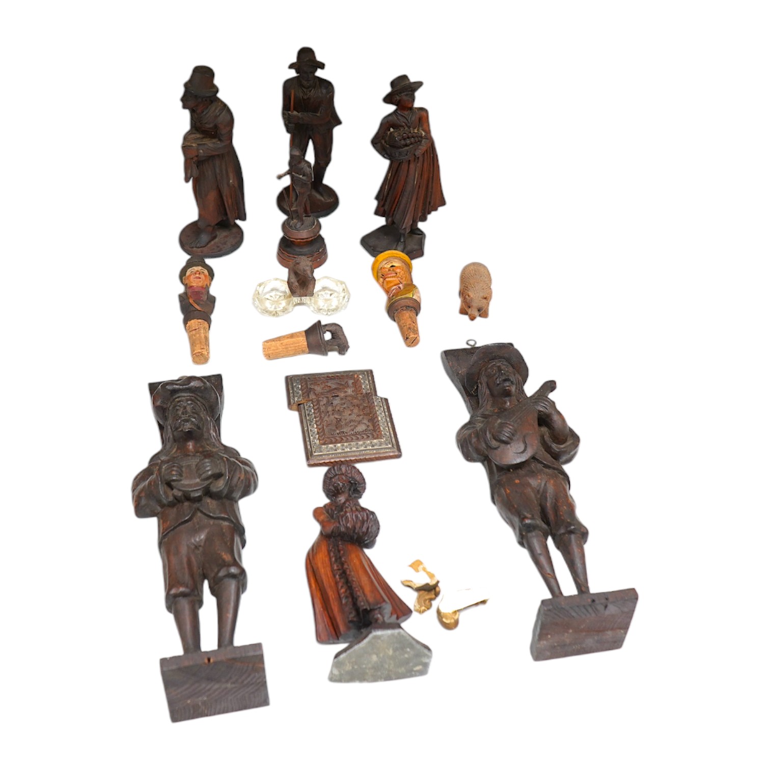 A collection of Black Forest wooden figurative carvings to include a pair of corbels in the form of musicians and a carved bear bottle stopper, largest 32cm high. Condition - mostly fair